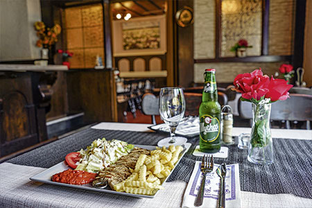 Grillteller mit Salat und Pommes auf gedecktem Tisch